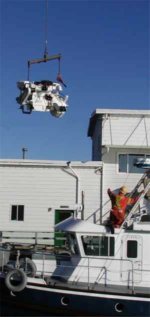 Lowering John Deere engine into the Coastal Messenger.